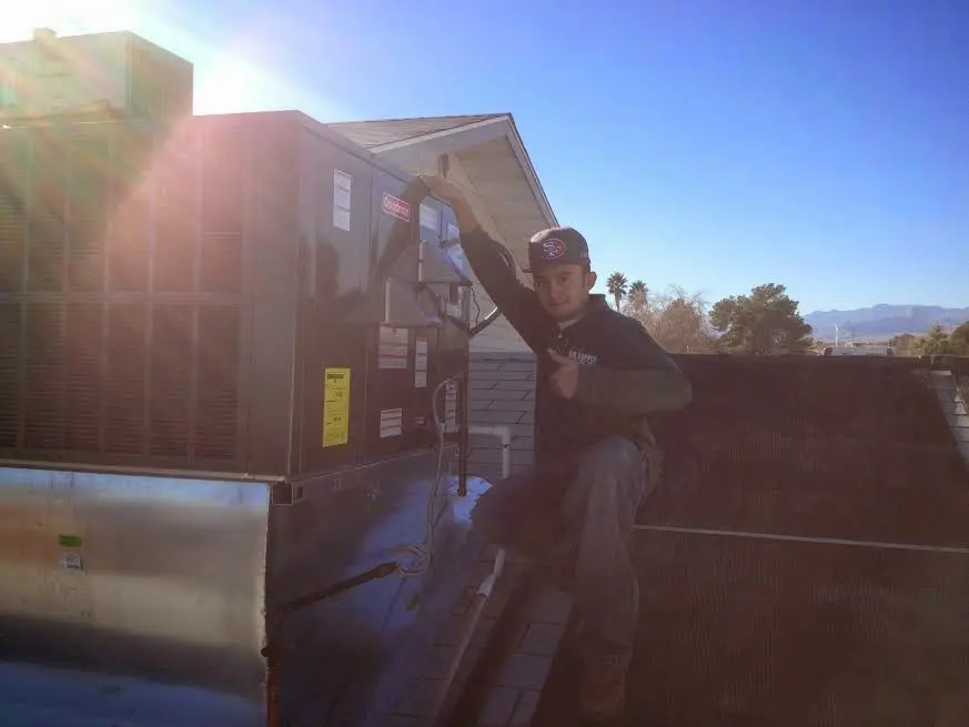 HVAC technician performing Air Duct Cleaning on a rooftop unit in Hewitt